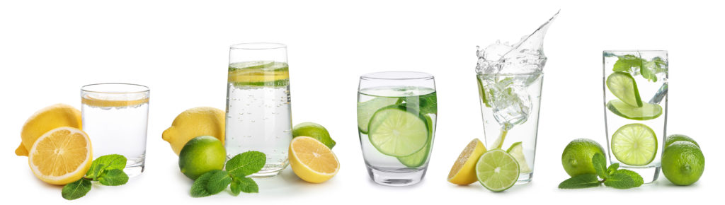 Glasses of infused water with citrus fruits on white background